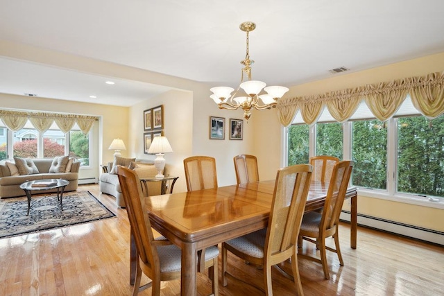 dining space featuring light wood finished floors, recessed lighting, a notable chandelier, and a baseboard radiator