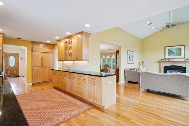 kitchen with visible vents, a ceiling fan, light wood-style floors, glass insert cabinets, and open floor plan