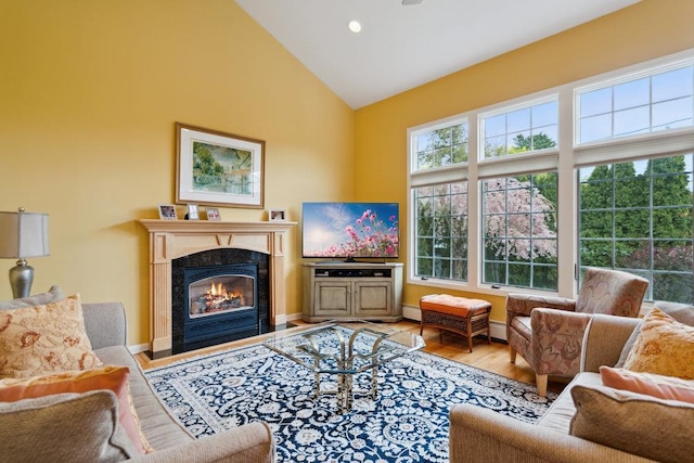 living area featuring high vaulted ceiling, recessed lighting, wood finished floors, and a fireplace
