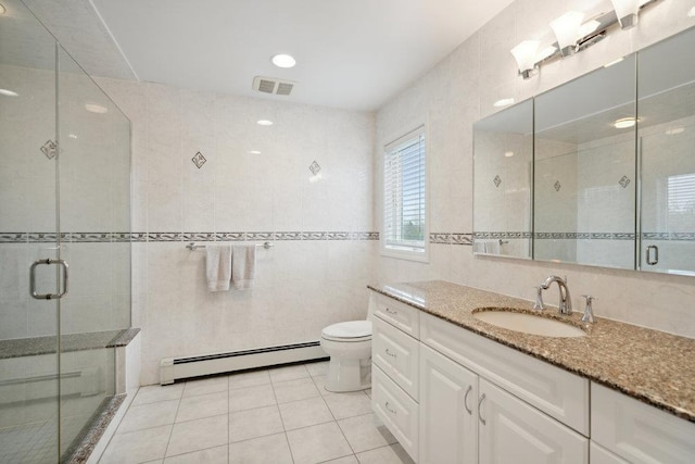 full bathroom featuring toilet, tile walls, baseboard heating, tile patterned flooring, and a shower stall