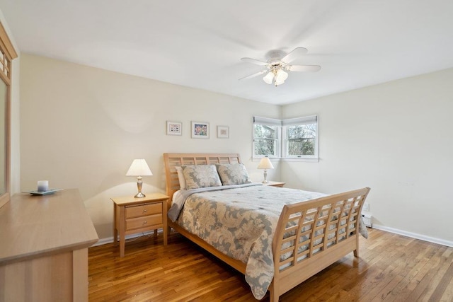bedroom with ceiling fan, baseboards, and wood finished floors