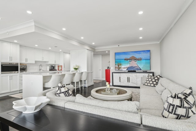 living area with crown molding, wood finished floors, and recessed lighting