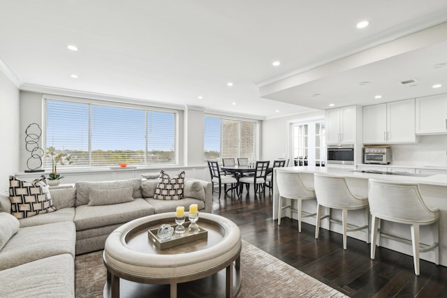 living area featuring a toaster, recessed lighting, ornamental molding, and dark wood-style flooring