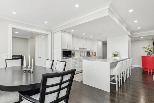 dining space with dark wood finished floors, baseboards, ornamental molding, and recessed lighting