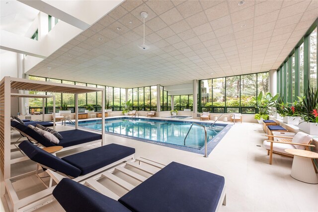 pool with an outdoor hangout area, a patio area, and an indoor hot tub