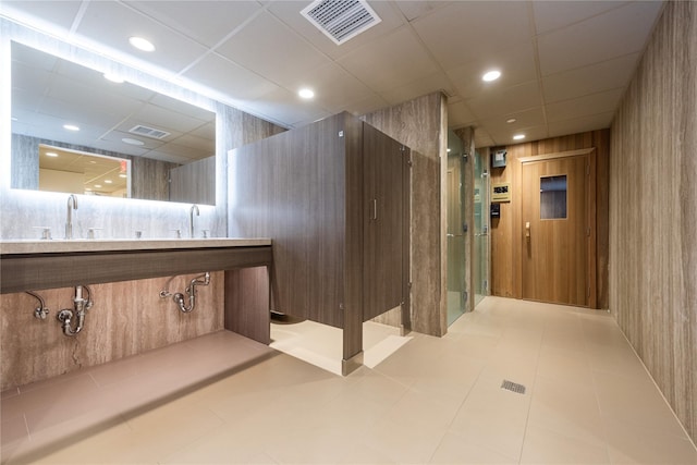full bath featuring tile patterned flooring, visible vents, a drop ceiling, and a sink