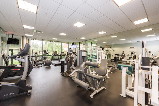 exercise room with floor to ceiling windows, a paneled ceiling, and visible vents