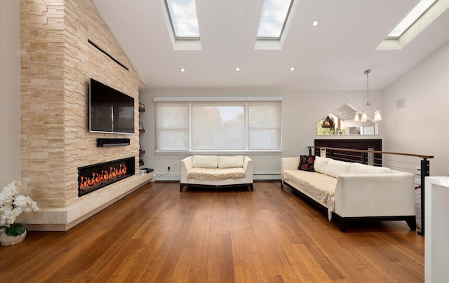 living area with baseboard heating, high vaulted ceiling, wood finished floors, a fireplace, and a skylight