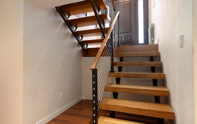 stairway with baseboards and wood finished floors