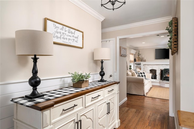 hallway featuring an inviting chandelier, crown molding, and dark wood-type flooring