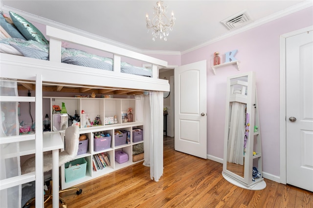 bedroom featuring crown molding, wood finished floors, an inviting chandelier, baseboards, and visible vents