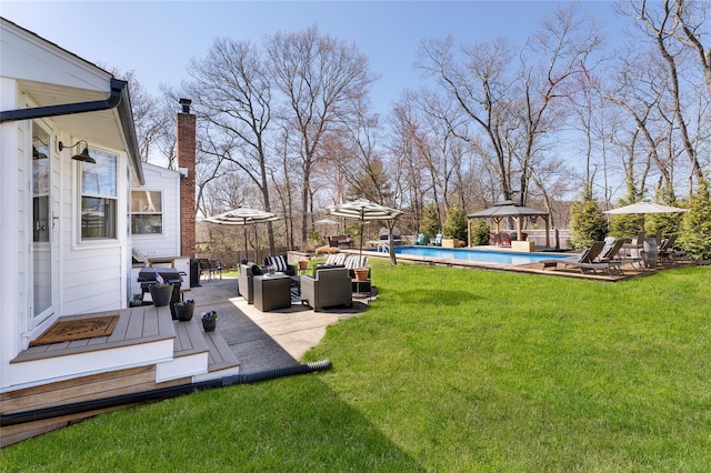 view of yard featuring outdoor lounge area, a patio area, a fenced in pool, and a gazebo
