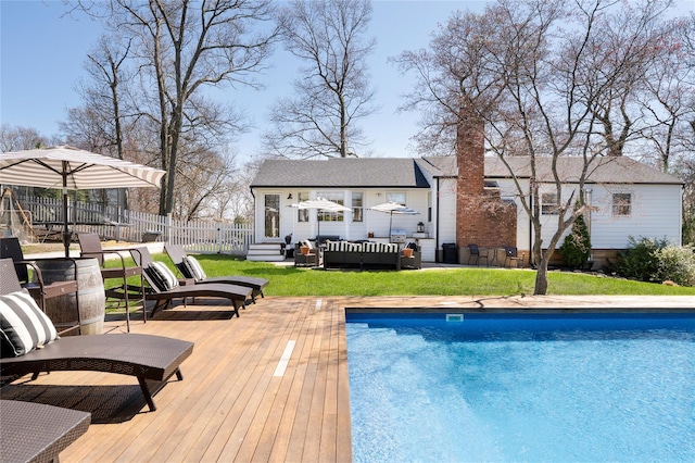 pool with fence, a wooden deck, a lawn, and outdoor lounge area