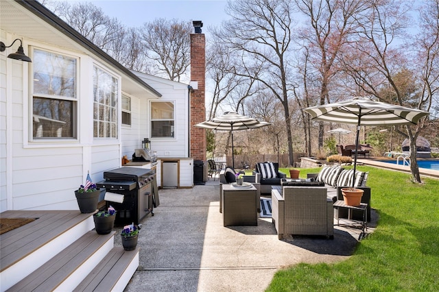 view of patio / terrace with a wooden deck, grilling area, a fenced in pool, and outdoor dining area