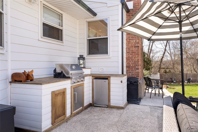 view of patio with grilling area, fence, and area for grilling