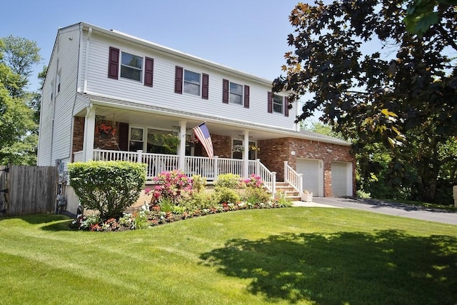 view of front facade featuring fence, a porch, a front lawn, and a garage