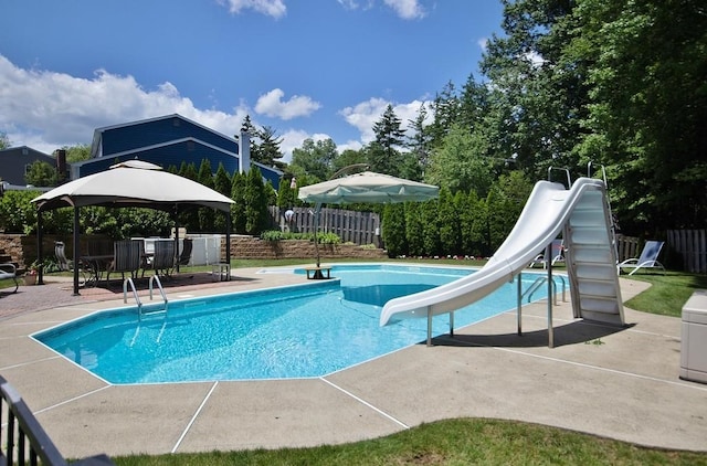 view of pool with fence, a gazebo, a fenced in pool, a water slide, and a patio