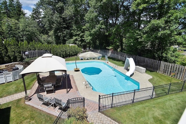 view of pool featuring a patio, a fenced in pool, a yard, a fenced backyard, and a water slide