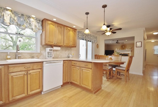 kitchen featuring light wood-style flooring, a sink, dishwasher, a peninsula, and a ceiling fan