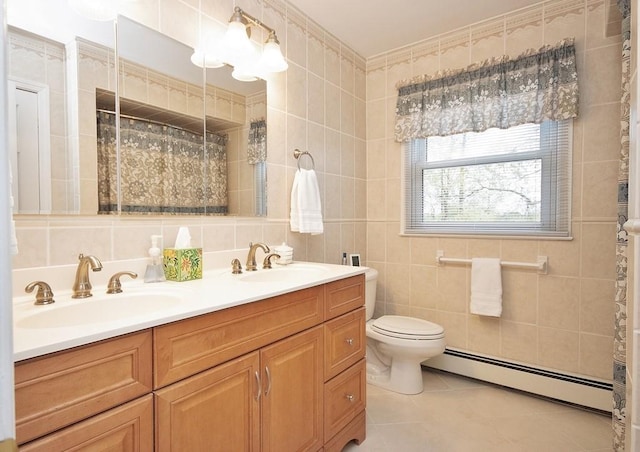 bathroom featuring baseboard heating, toilet, tile patterned flooring, and a sink