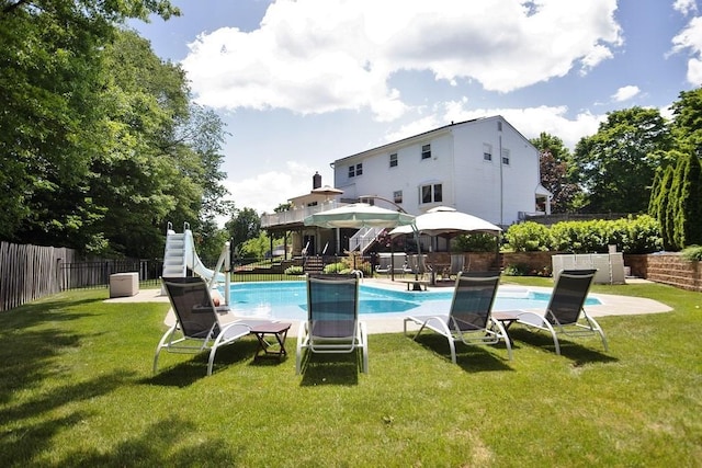 view of swimming pool featuring a yard, a gazebo, a water slide, and a fenced backyard