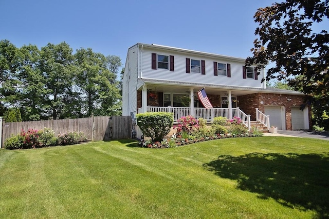 view of front of home with a porch, fence, driveway, a front lawn, and an attached garage