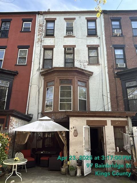 back of property featuring cooling unit and brick siding