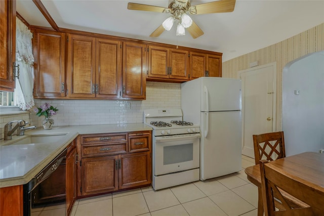 kitchen featuring a sink, white appliances, light countertops, arched walkways, and a ceiling fan