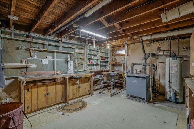 below grade area with a heating unit, a workshop area, and water heater