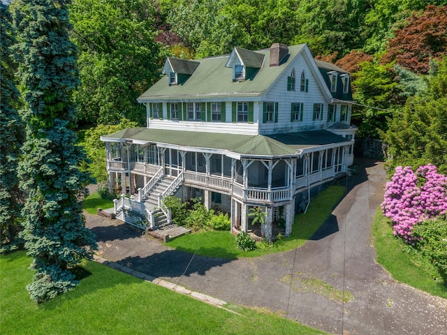 225 River Rd, Nyack, NY 10960 - view of front facade with a chimney, asphalt driveway, a front lawn, and a wooded view