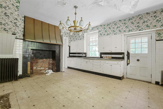 225 River Rd, Nyack, NY 10960 - kitchen featuring wallpapered walls, a chandelier, light flooring, white cabinets, and radiator heating unit