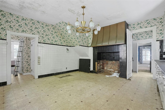 225 River Rd, Nyack, NY 10960 - unfurnished living room with wallpapered walls, light floors, a fireplace, and a chandelier