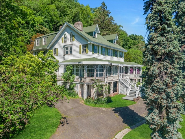 225 River Rd, Nyack, NY 10960 - view of front facade featuring a chimney, a sunroom, stairs, and driveway