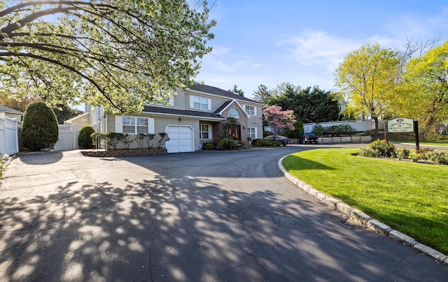 100 Glen Cove Rd, Greenvale, NY 11548 - view of front of home with an attached garage, fence, a front lawn, and aphalt driveway