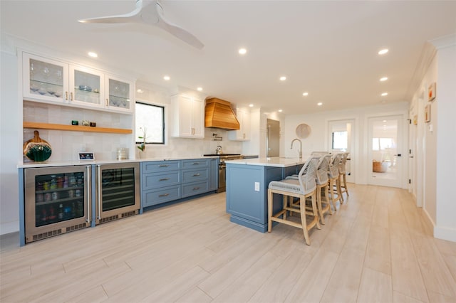 923 Oceanfront, Long Beach, NY 11561 - kitchen featuring custom exhaust hood, beverage cooler, stainless steel range, healthy amount of natural light, and crown molding