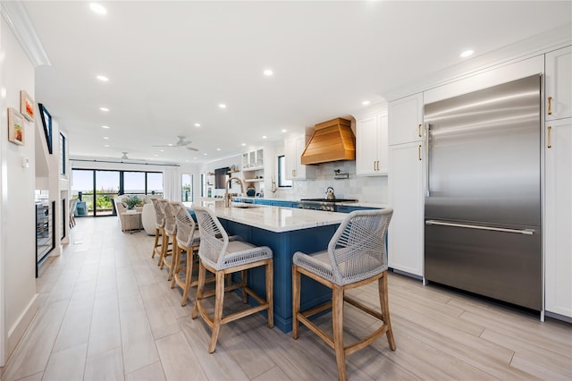 923 Oceanfront, Long Beach, NY 11561 - kitchen with built in refrigerator, custom exhaust hood, white cabinets, recessed lighting, and a large island