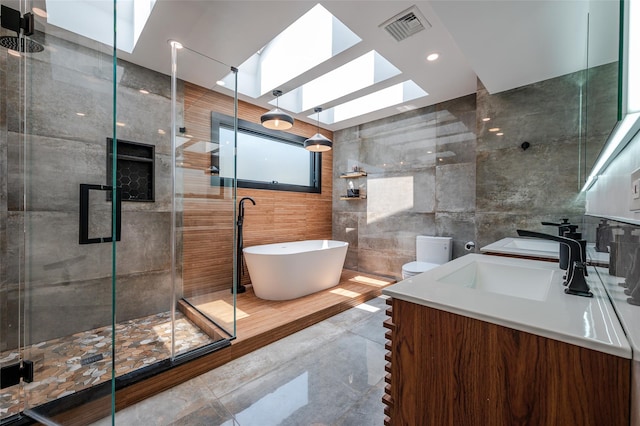 923 Oceanfront, Long Beach, NY 11561 - bathroom featuring a skylight, tile walls, vanity, a freestanding tub, and a stall shower