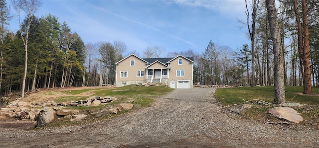 traditional-style home featuring a front yard, dirt driveway, and an attached garage