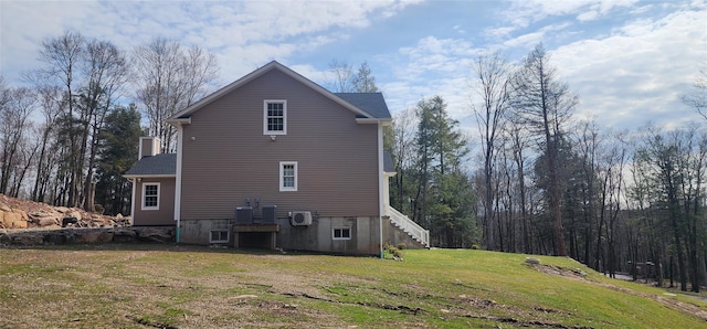view of side of property with stairs, a yard, and central AC