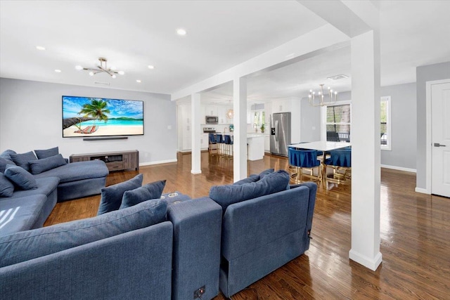 living room featuring recessed lighting, baseboards, a chandelier, and dark wood-type flooring
