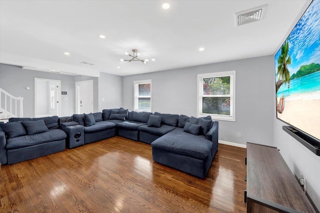 living area with dark wood-style flooring, a notable chandelier, recessed lighting, visible vents, and stairway