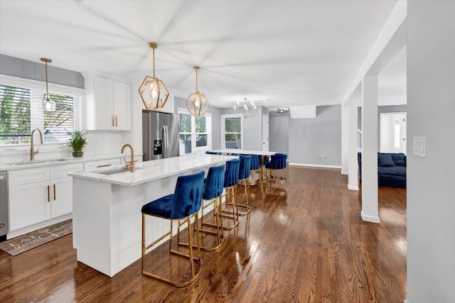 kitchen with stainless steel refrigerator with ice dispenser, a sink, and a spacious island