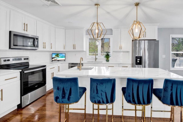 kitchen featuring stainless steel appliances, visible vents, decorative backsplash, and a sink