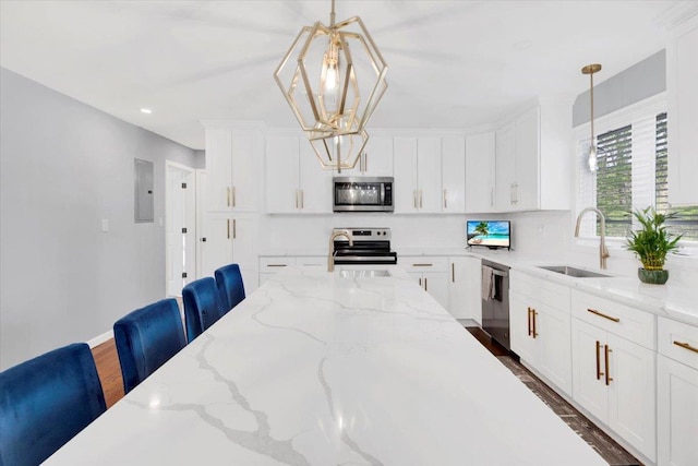 kitchen with a sink, appliances with stainless steel finishes, white cabinets, and dark wood finished floors