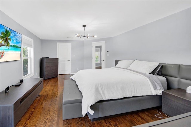 bedroom with a chandelier, wood finished floors, and visible vents