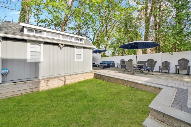 view of yard featuring fence, an outdoor structure, and a patio