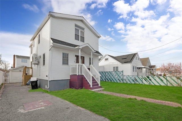 71 E Kissimee Rd, Lindenhurst, NY 11757 - view of front facade featuring an outdoor structure, fence, aphalt driveway, and a front yard