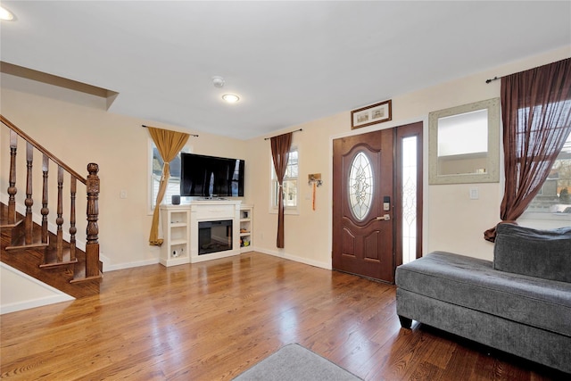 71 E Kissimee Rd, Lindenhurst, NY 11757 - entrance foyer featuring baseboards, a glass covered fireplace, recessed lighting, wood finished floors, and stairway