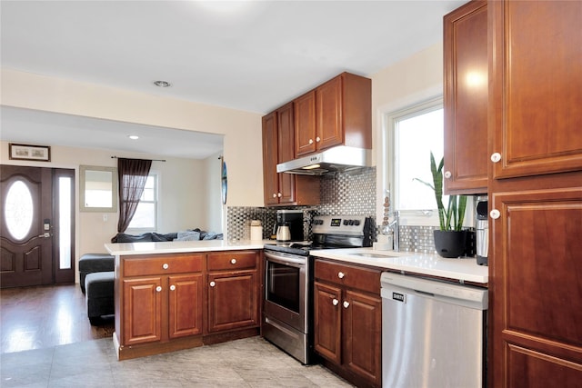 71 E Kissimee Rd, Lindenhurst, NY 11757 - kitchen featuring a peninsula, light countertops, appliances with stainless steel finishes, and under cabinet range hood