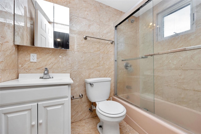 71 E Kissimee Rd, Lindenhurst, NY 11757 - bathroom featuring tile walls, vanity, bath / shower combo with glass door, and toilet